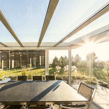 Sonnenlicht strömt durch einen Kalt-Wintergarten; wir betrachten die Vorteile und Nachteile verschiedener Himmelsrichtungen für Winter- und Sommergärten.