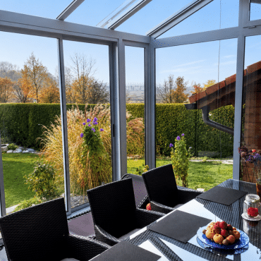 Wintergarten in Rohrbach mit großen Glasflächen, Essbereich und freiem Blick in den herbstlichen Garten