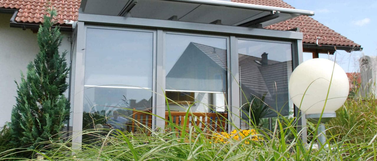 Wintergarten Material in Kunststoff/Aluminium mit grossen Glasflächen und moderner Konstruktion am Wohnhaus.
