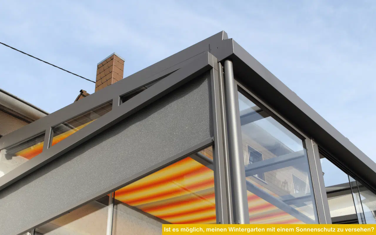 Ein heller Wintergarten mit Home-Office-Bereich, vielen Pflanzen und einfallenden Sonnenstrahlen durch die Glasfront.