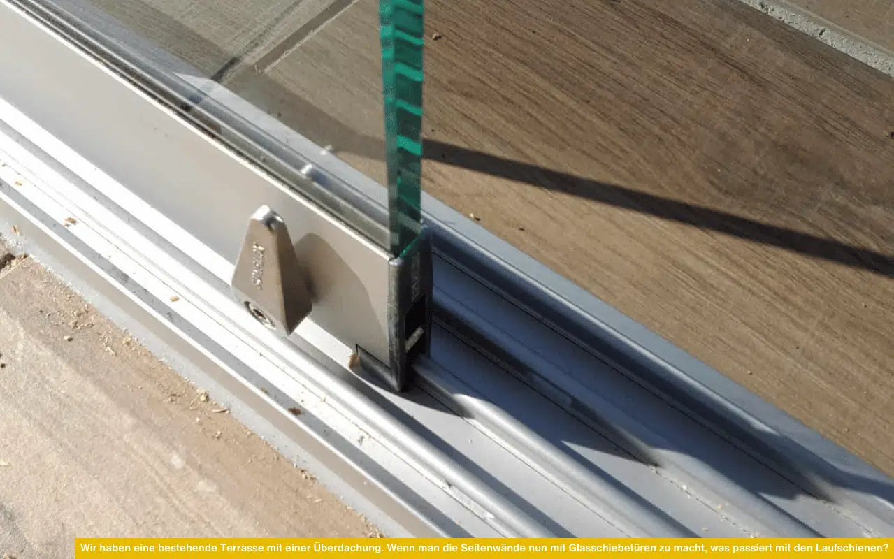 Nahaufnahme einer eingelassenen Laufschiene mit Glas-Element, montiert auf einem Bodenbelag aus Holzoptik.