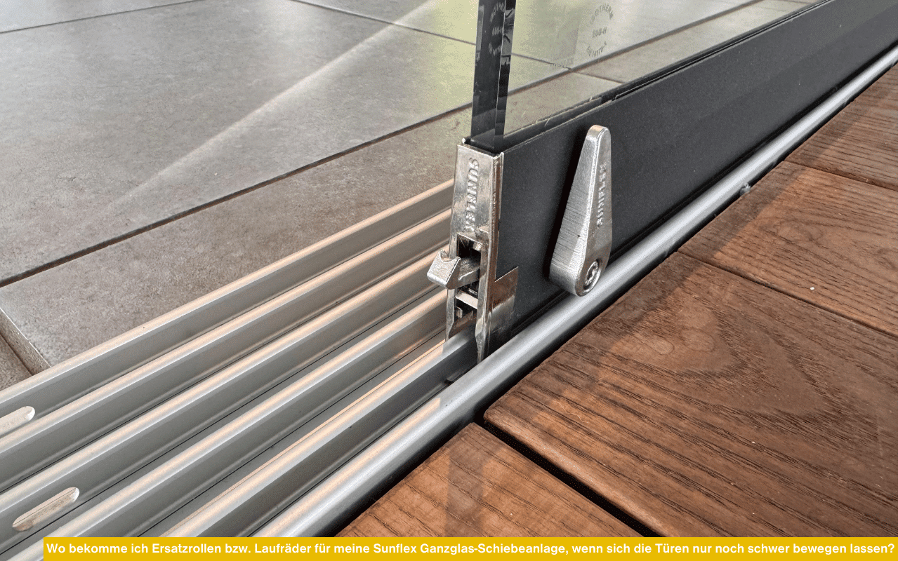 Nahaufnahme einer Aluminium-Laufschiene mit montierter Glas-Schiebetür. Sichtbar ist ein Metallbeschlag mit SUNFLEX-Gravur, eingebaut in den unteren Rahmenbereich der Türanlage.