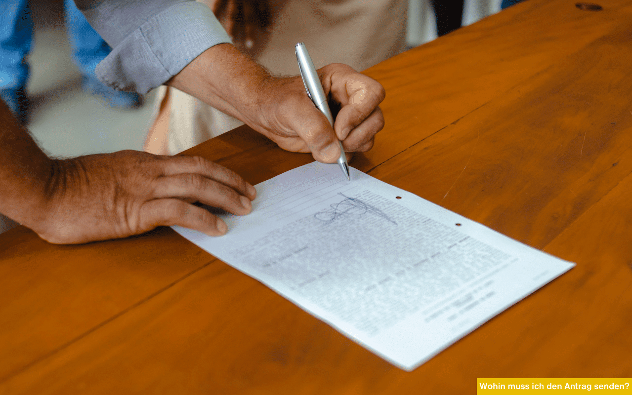 Wohin muss ich den Antrag senden Person unterschreibt ein Formular am Tisch zur Einreichung eines Antrags