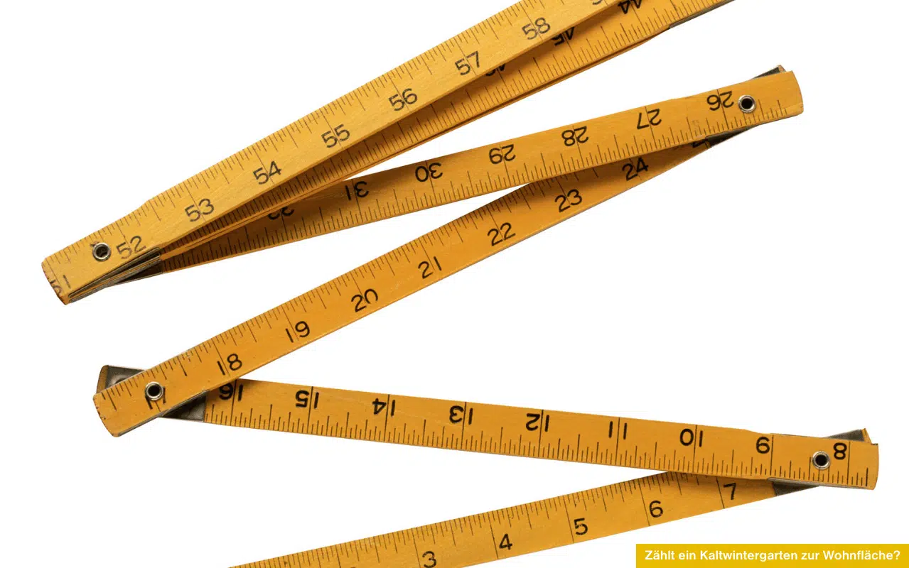 Zählt ein Kaltwintergarten zur Wohnfläche Gelber Zollstock aufgefaltet auf weißem Hintergrund als Symbol für Flächenberechnung und Maße